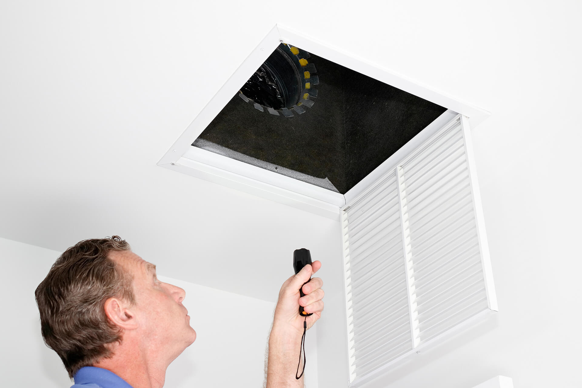 man inspecting air ducts